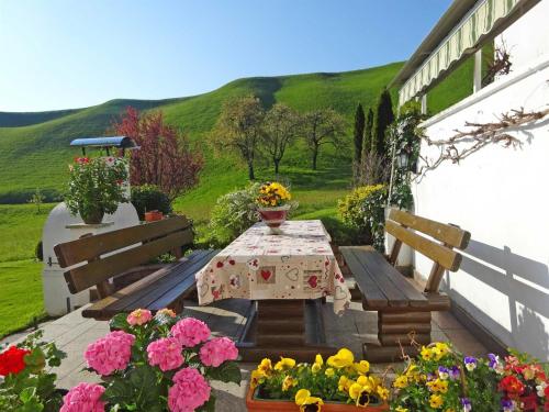 a table and benches in a garden with flowers at Landhaus Alpenblick in Wiesing