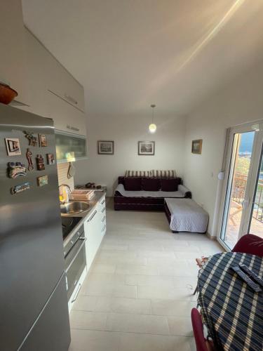 a kitchen and living room with a couch in the background at Cv apartment in Herceg-Novi