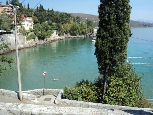 a river with a tree and a no swimming sign at Apartment Sand Beach in Opatija