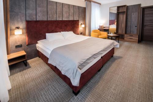 um quarto de hotel com uma cama grande e uma cadeira em Байків em Ternopilʼ