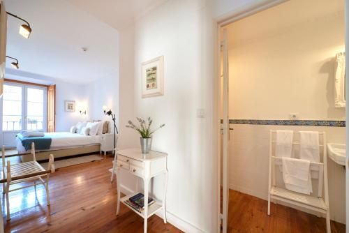 a bathroom with a sink and a bedroom with a bed at Casa do Mercado Lisboa in Lisbon