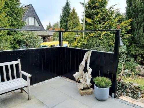 a wooden fence with a bench on a patio at Waldhaus in Kerschenbach