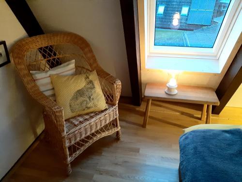 a wicker chair with a pillow sitting next to a window at Waldhaus in Kerschenbach
