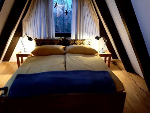 Cette chambre comprend un grand lit et une fenêtre. dans l'établissement Waldhaus, à Kerschenbach