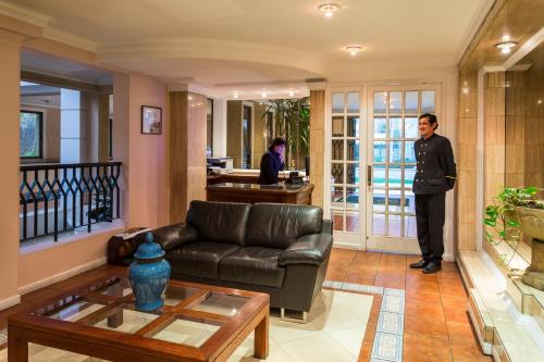 a man standing in a living room with a couch at Park Plaza Apartments in Santiago
