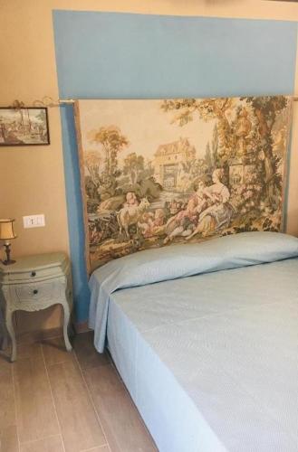 een slaapkamer met een schilderij aan de muur naast een bed bij Runamonte camere in Perugia