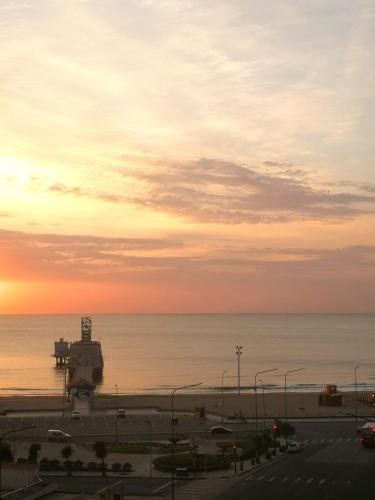 a sunset over the ocean with a parking lot at Gran Hotel Manila in Mar del Plata