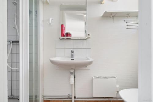 ein Bad mit einem Waschbecken und einem Spiegel in der Unterkunft Semesterboende på Hällestrand, Strömstad in Strömstad