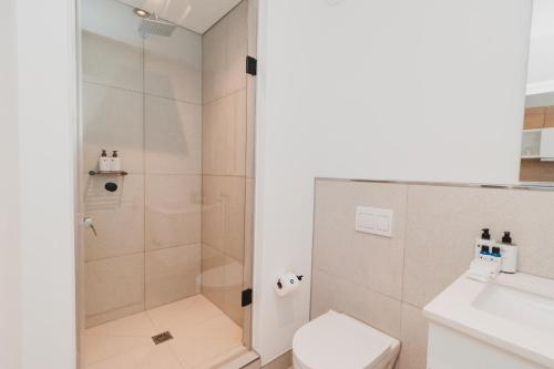 a bathroom with a shower and a toilet and a sink at Bridgewater Apartments by Century City Hotels in Cape Town
