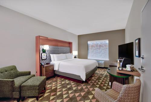 a bedroom with a bed and a chair and a desk at Holiday Inn - Erie by IHG in Erie