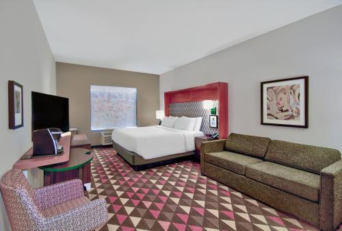 a hotel room with a bed and a couch at Holiday Inn - Erie by IHG in Erie