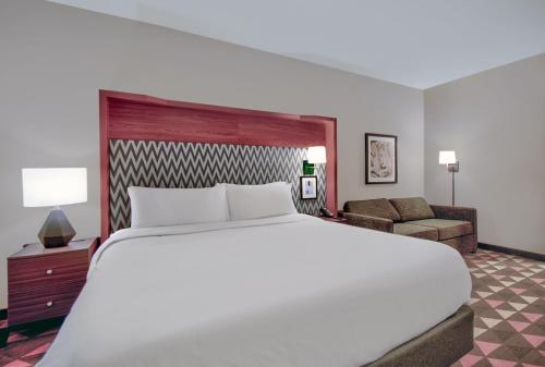 a bedroom with a large bed and a living room at Holiday Inn - Erie by IHG in Erie