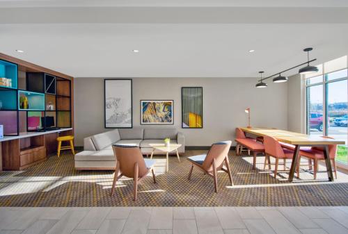 a living room with a table and chairs and a couch at Holiday Inn - Erie by IHG in Erie