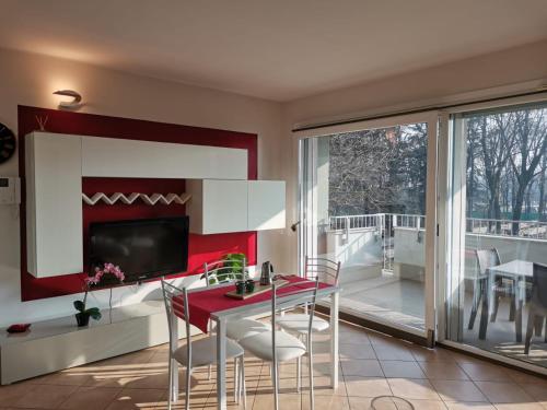 a living room with a table and chairs and a television at Bnbook - Metropolitan Expo Flat in Rho