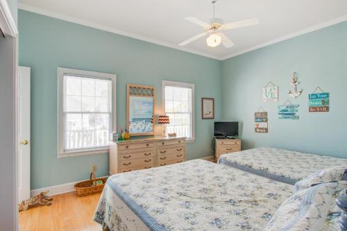 a bedroom with two beds and a ceiling fan at Sweet Trade in Holden Beach