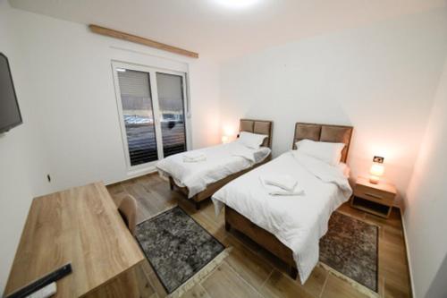 Habitación con 2 camas y ventana en Zlatna Nit, en Novi Pazar