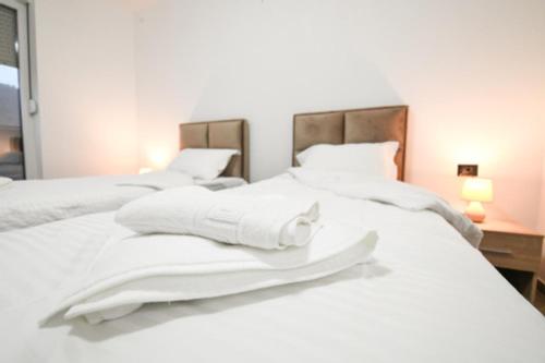 a white bed with white sheets and pillows on it at Zlatna Nit in Novi Pazar
