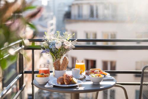 a table topped with plates of food and drinks at Hotel Yllen Eiffel in Paris