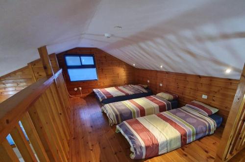an attic bedroom with two beds and a window at Mazal shell Zimmer in Amirim