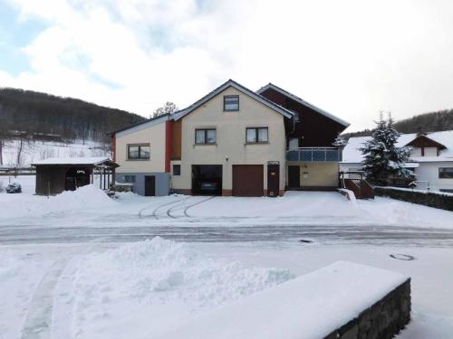 uma casa com muita neve à frente em Ferienwohnung Krenzer em Ehrenberg