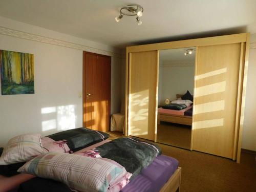 um quarto com uma cama e um espelho e um quarto em Ferienwohnung Krenzer em Ehrenberg