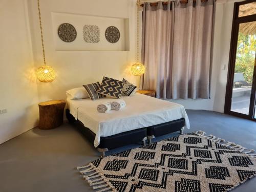 a bedroom with a bed and a rug at Hotel Playa Mandala in Palomino