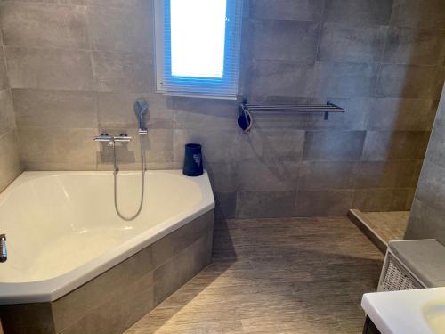 a bathroom with a bath tub and a shower at VILLA CHJOSELLA 150M2 PISCINE ET AU CALME in Santa-Reparata-di-Balagna