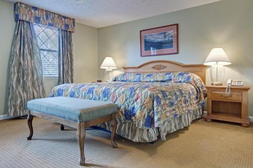 a bedroom with a bed and a table and a chair at Mountain Meadows by Exploria Resorts in Pigeon Forge