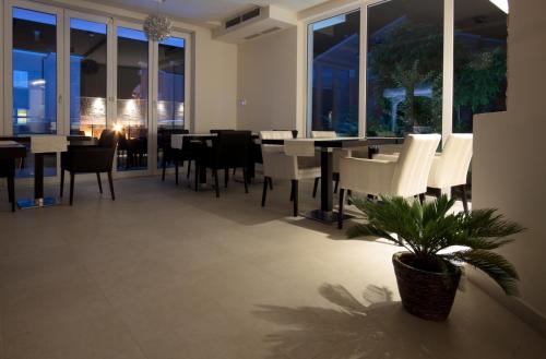 a dining room with tables and chairs and a plant at House Novalia in Novalja
