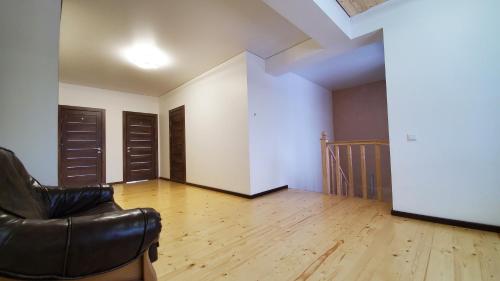 a living room with a leather chair and wooden floors at SPA Resort Villa Sofia in Yablunytsya