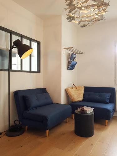 - un salon avec deux canapés bleus et une lampe dans l'établissement L' Appart du Marché, à La Rochelle