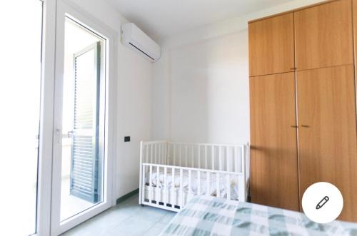 - une chambre avec un lit bébé et une grande fenêtre dans l'établissement Deliziosa Villetta Mare Indipendente, à Marina di Pisticci