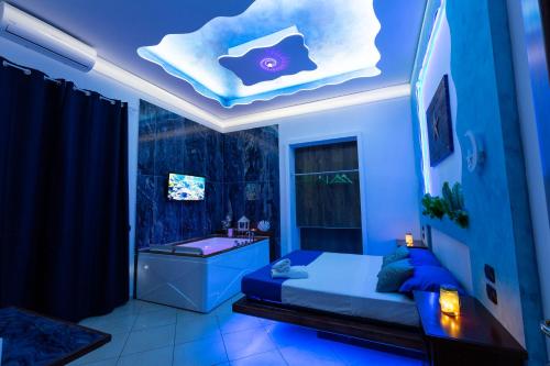 a blue room with a bed and a bath tub at Pompei Luxury Rooms in Pompei