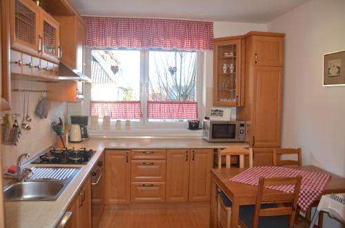 a kitchen with wooden cabinets and a sink and a window at Villa Tatran in Stará Lesná