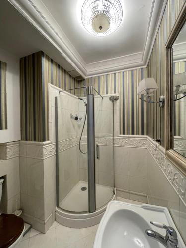 uma casa de banho com um chuveiro, uma banheira e um lavatório. em Poznańska Street Apartment em Varósvia