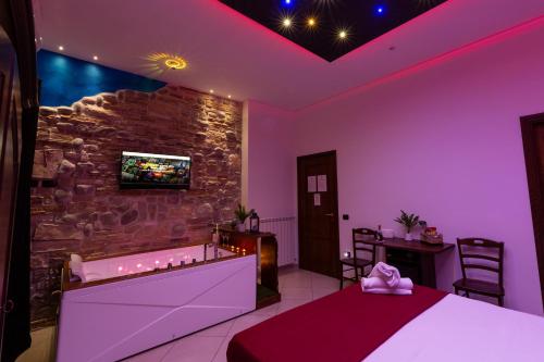 a bedroom with a bed and a stone wall at Pompei Luxury Rooms in Pompei