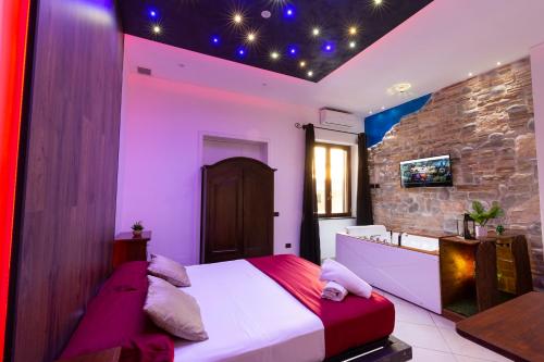 a bedroom with a bed and a stone wall at Pompei Luxury Rooms in Pompei