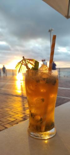 a drink sitting on a table next to the beach at Little Surf House Hostel in Las Palmas de Gran Canaria