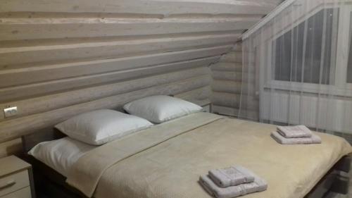 拉澤希納的住宿－Шепіт лісу，一间卧室配有一张床,上面有两条毛巾