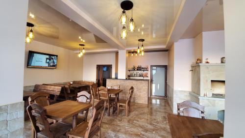 a restaurant with wooden tables and chairs and a bar at SPA Resort Villa Sofia in Yablunytsya
