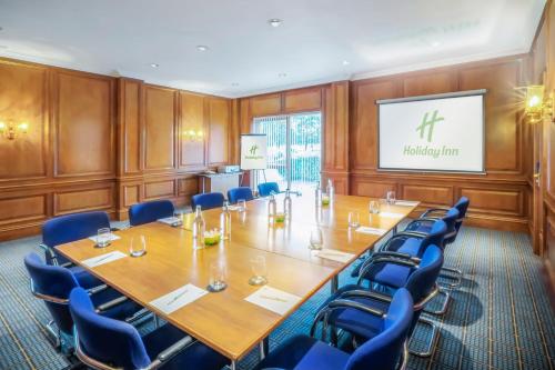 a conference room with a large wooden table and blue chairs at Holiday Inn Hull Marina by IHG in Hull