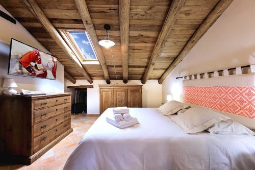 a bedroom with a large white bed with a wooden ceiling at Casa Sunalle in Fonni