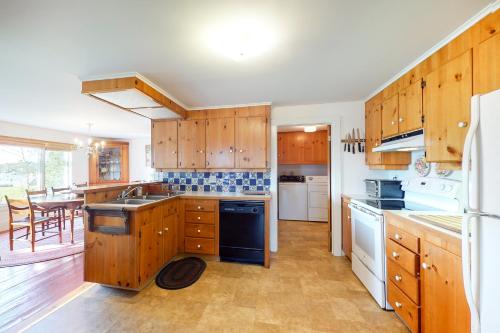 a large kitchen with wooden cabinets and a table at Heluvaspot in Port Clyde
