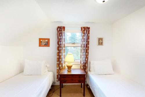 two twin beds in a room with a window at Heluvaspot in Port Clyde