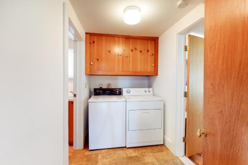 a kitchen with a white dishwasher and wooden cabinets at Heluvaspot in Port Clyde