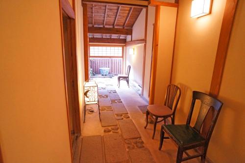 a hallway with two chairs and a table in a room at Mujinzo in Yufuin