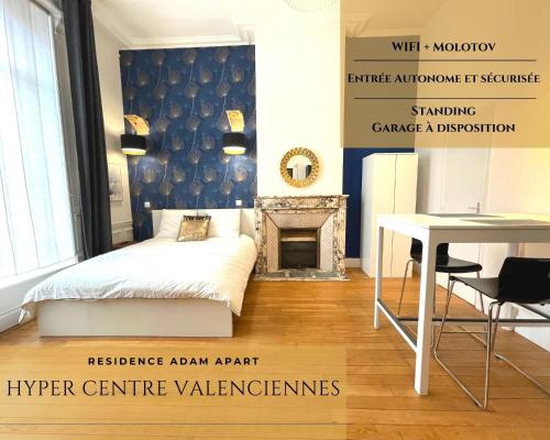 a bedroom with a bed and a table and a fireplace at Résidence Adam à part in Valenciennes