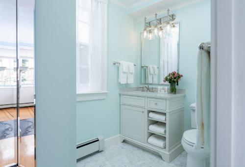 a bathroom with a sink and a toilet and a mirror at Candleberry Inn on Cape Cod in Brewster