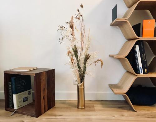 a vase with flowers in it next to a book shelf at Home Sweet Home in Cognac