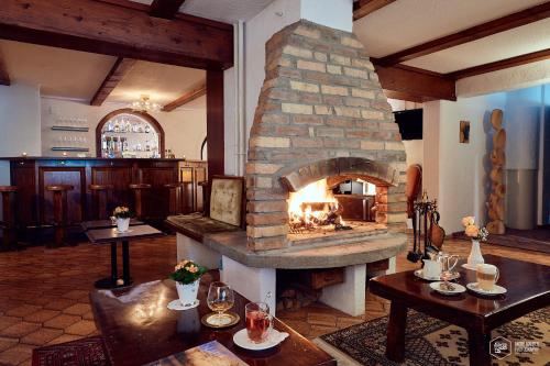 a large stone fireplace in a room with tables at Seilers Vintage Hotel & Spa in Kandersteg